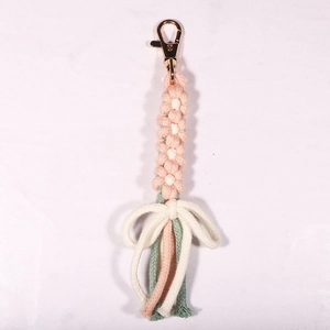 Close-up of pink and white handmade crochet daisy keychain with a gold lobster clasp