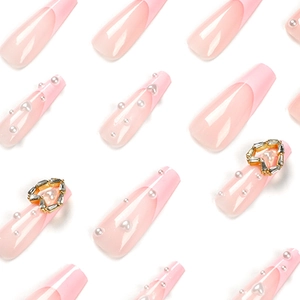 Pink French press-on nails with white pearls, rhinestone hearts, and long coffin shape
