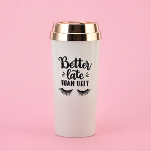 Close-up of white coffee travel mug with gold lid and Better late THAN UGLY slogan
