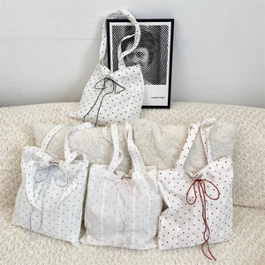 Detail of Korean style tote bags with heart patterns and functional drawstring closures
