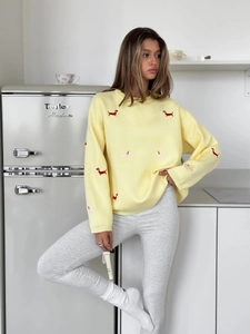 Close-up of cute dachshund dog embroidery on a yellow knit sweater