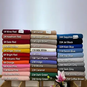 Soft solid cashmere scarves in 34 vibrant colors displayed on a wooden stand