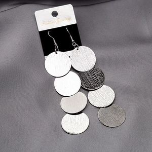 Detail of silver layered hollow round metal sequins on stylish fashion drop earrings
