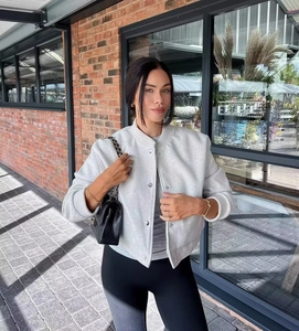 Détails de la veste baseball gris clair avec boutons métalliques et bords-côtes