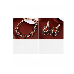 Vue détaillée du collier et des boucles d'oreilles vintage en émail avec cristaux rouges
