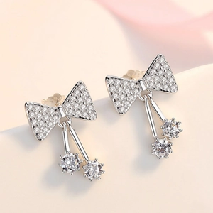 Macro shot of silver bow tassel earrings with S925 mark and sparkling cubic zirconia