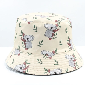 Close-up of beige bucket hat featuring cute cartoon koala and green leaf prints