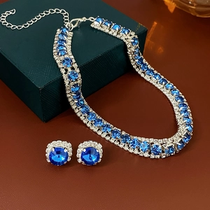 Detailed view of luxury blue square crystal necklace and earring set on a dark jewelry box