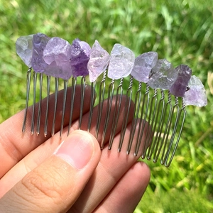 Macro shot of natural amethyst raw stones hand-wired to a silver metal hair comb