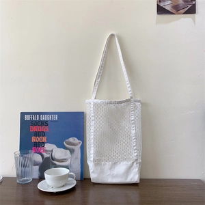 Detail of white mesh patchwork canvas tote bag showing breathable woven texture