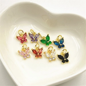 Pendentifs papillon colorés sertis de zircons présentés dans un plateau en coeur