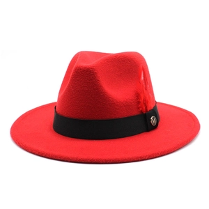 Détail d'un chapeau en feutre avec ruban noir, plume rouge et boucle dorée avec logo M