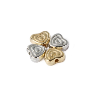 Macro shot of heart-shaped CCB beads in gold and silver finish for DIY jewelry