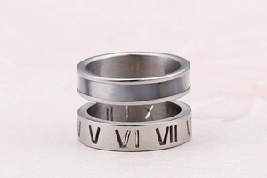 Detailed view of stacked stainless steel rings featuring Roman numerals and a dark inlay