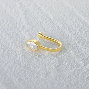 Macro view of gold S925 sterling silver U-shaped nose cuff with pear-cut zircon stone