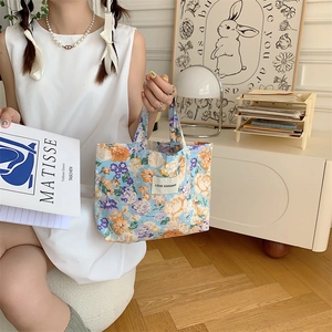 Détail d'un sac cabas vintage en toile fleurie avec étiquette Love Sozakka de style artistique