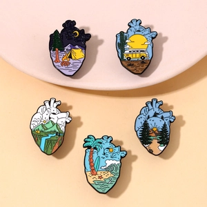 Detail of five anatomical heart enamel pins featuring various landscape illustrations