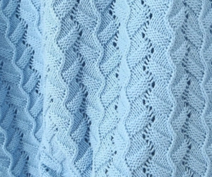 Gros plan du tricot torsadé bleu clair avec détails complexes de crochet ajouré