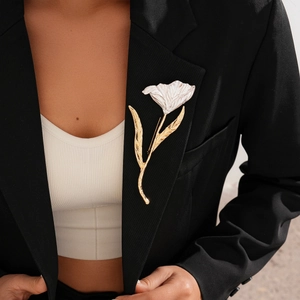 Close-up of cream white tulip flower brooch pinned on a black business blazer