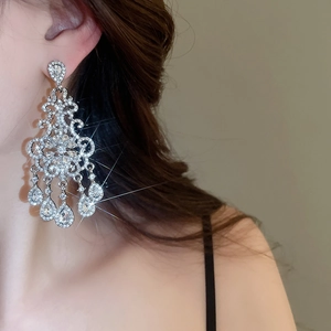 Macro shot of silver-toned flower tassel earrings with dangling water drop crystal pendants