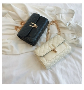 Detail of quilted diamond pattern on black and white crossbody bags with gold chain