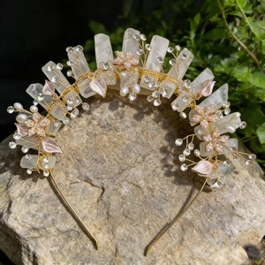 Detail of handmade gold crown with raw pink crystals, floral accents, and small pearls