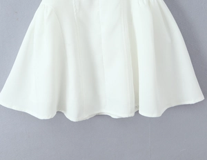 Detailed shot of white fabric hemline showing high-quality stitching and dress texture