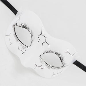 Macro detail of gothic white Day of the Dead mask with hand-painted black crackle patterns