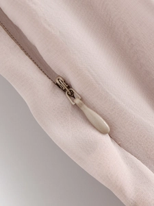 Close-up of a high-quality invisible zipper on pink elegant cocktail dress fabric