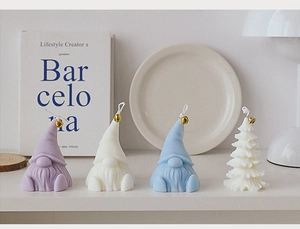 Detailed view of gnome and Christmas tree scented candles with small golden bells
