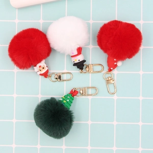 Detail view of 4 festive Christmas pompom keychains with Santa and Snowman charms