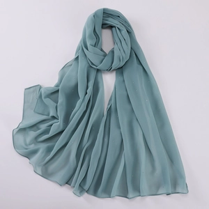 Detailed macro view of gray-blue pearl chiffon scarf with shimmering silver rhinestones