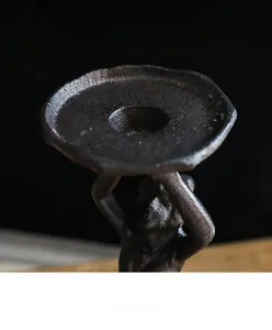 Detailed macro view showing the stable flat tray of the vintage cast iron angel candle holder