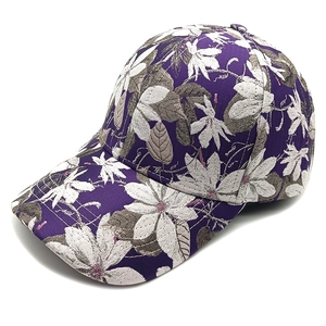Detail der lila Baseballkappe mit weißem Magnolien-Print und feiner Twill-Gewebe-Struktur