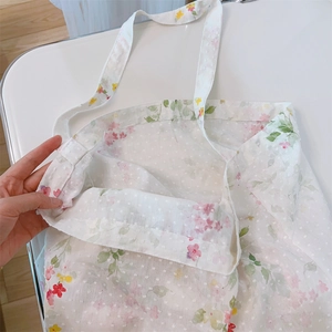 Detail of floral printed cotton tote bag showing light translucent lace texture