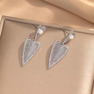 Sparkling heart pearl earrings with brushed silver texture and rhinestones on gold tray