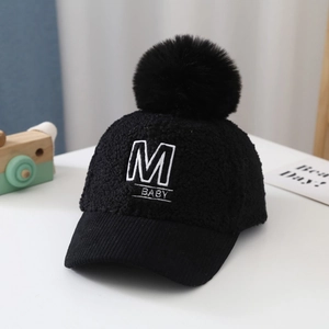 Detail of black winter teddy fleece baby baseball cap with large faux fur pompom and M embroidery