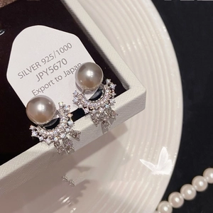 Macro view of 925 silver pearl drop earrings with crystal fringe in a white gift box