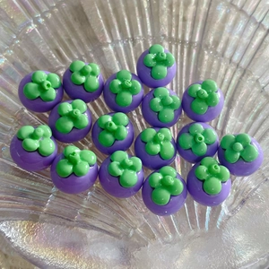 Dettaglio macro di perline a mangostano in resina viola per gioielli fai-da-te in vassoio
