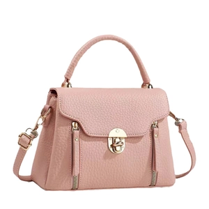 Pink lychee texture handbag with gold lock and adjustable strap on white background