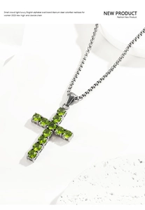 Detail of cross necklace with green zircon inlay on high-quality titanium steel chain