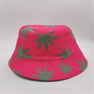 Close-up of reversible bucket hat featuring vibrant pink fabric and green leaf pattern
