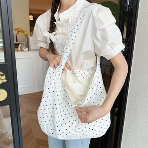 Polka dot canvas tote bag detail showing internal zipper pocket and large capacity