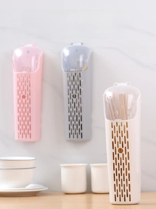 Dettaglio di portaposate a muro in plastica con coperchi antipolvere in tre colori pastello