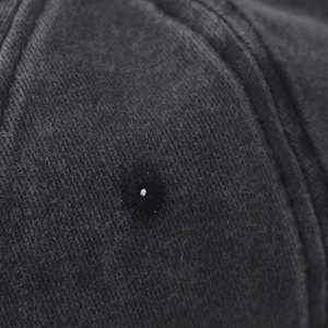 Dettaglio macro di un occhiello ricamato e tessuto twill lavato su un berretto da baseball