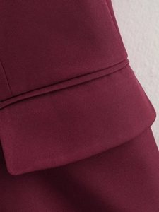 Dettaglio del blazer rosso vino con trama in tessuto twill e cuciture della tasca