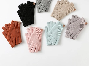 Flat lay of colorful thick winter knitted gloves featuring brown leather brand labels
