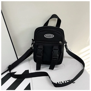 Dettaglio della borsa a tracolla in nylon nero con fibbie decorative e patch fashion