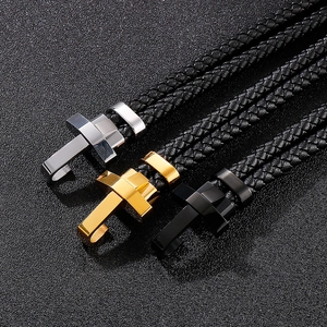 Gros plan de bracelets en cuir tressé avec boucles en croix argent, or et noir