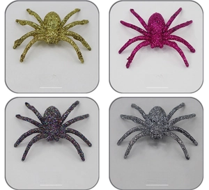 Macro detail of glittery Halloween spider decorations in gold, pink, silver and multicolor